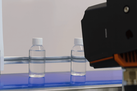 Bottles passing a vision station that checks fill level and cap seating